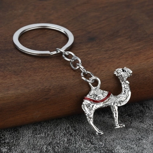Détail d'un porte-clés chameau en alliage argenté avec cristaux blancs et émail rouge