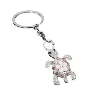 Silver turtle keychain with pink crystals and flower pattern on a white background