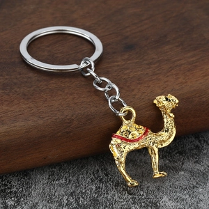 Porte-clés chameau doré orné de strass présenté sur un support de bureau en bois