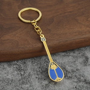 Detailed close-up of a blue enamel lute keychain with a golden metallic finish