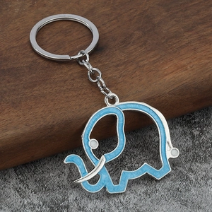 Sky blue enamel elephant keychain with silver alloy ring on a premium wood and stone backdrop