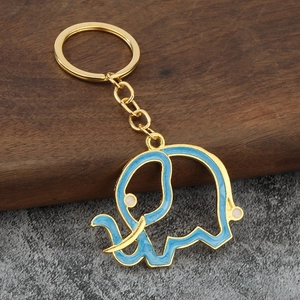 Close-up of golden elephant keychain with blue enamel filling and hollow detailing