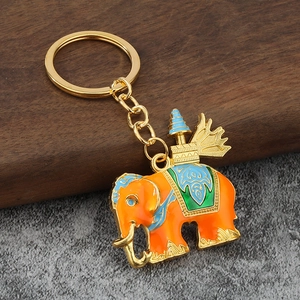 Detailed shot of an exotic golden elephant keychain with orange enamel and blue accents