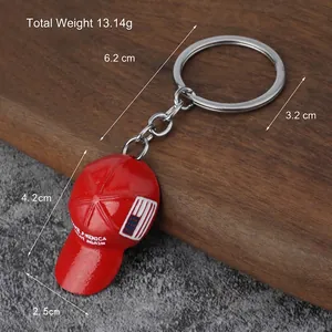 Red baseball cap keychain with US flag and MAGA slogan on a silver keyring