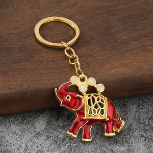 Portachiavi a forma di elefante dorato con smalto rosso e intagli su base di legno