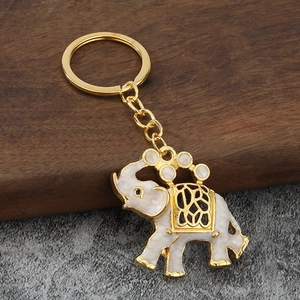 Dettaglio del portachiavi a elefante dorato con smalto crema e motivi traforati