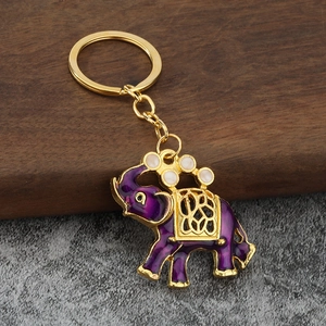 Dettaglio portachiavi con elefante thailandese in smalto viola e decorazioni dorate traforate
