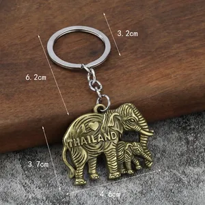 Vintage bronze elephant keychain with I Love Thailand engraving on wood and concrete