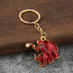 Detail of red enamel elephant keychains with gold plating and glossy oil drip finish