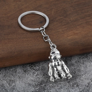 Macro shot of silver metal gorilla keychain on dark wood and grey stone texture
