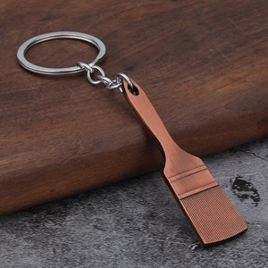 Macro shot of creative metal shovel keychain with vintage bronze finish on wood