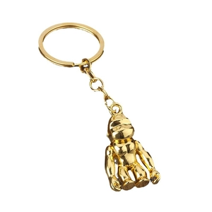 Polished gold-colored gorilla pendant keychain with round metal ring on white background