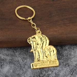 Golden elephant keychain with I Love Thailand engraved charm on a wooden background