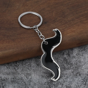 Creative silver metal mustache keychain with black enamel on a rustic wood background