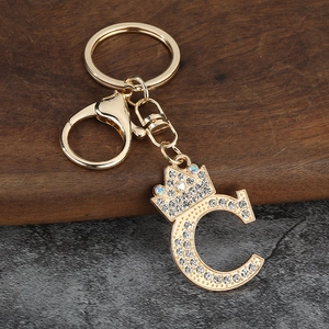 Vue macro d'un porte-clés lettre C doré avec couronne en cristal et fermoir mousqueton