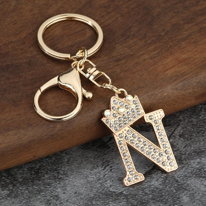 Détail du porte-clés lettre N dorée avec couronne et strass pour sac à main
