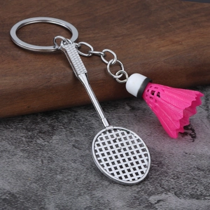 Detailed close-up of a silver badminton racket keychain with a bright pink shuttlecock