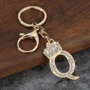Gros plan du porte-clés lettre Q doré avec strass brillants et décoration couronne