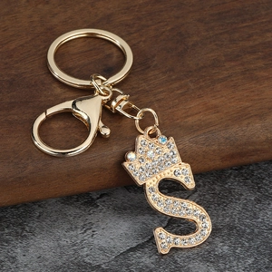 Détail du porte-clés lettre S dorée avec couronne et strass blancs étincelants
