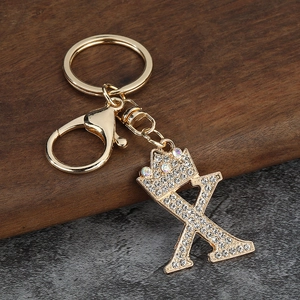 Détail d'un porte-clés doré avec couronne et lettre K orné de strass pour sacs