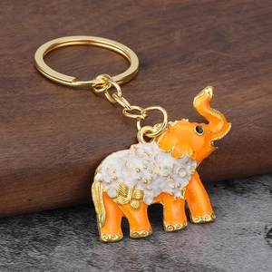 Detailed close-up of orange elephant keychain with gold butterfly pattern and enamel finish
