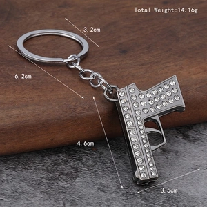 Grey metal pistol keychain with shiny white crystals and size specifications