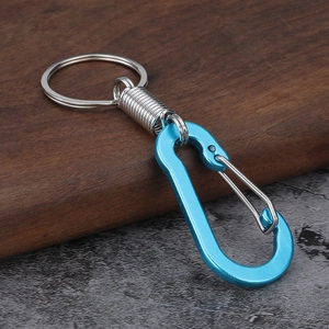 Blue D-ring aluminum carabiner keychain with silver spring coil on a dark textured surface