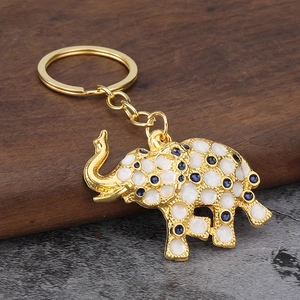 Golden elephant keychain with white enamel petals and blue crystals in a 45-degree view