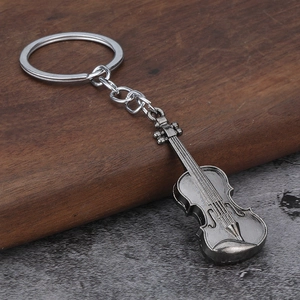 Detailed view of vintage metal violin keychain with realistic antique silver finish