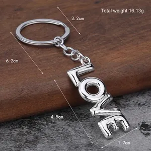 Portachiavi con lettere LOVE argento in stile palloncino su fondo legno e pietra