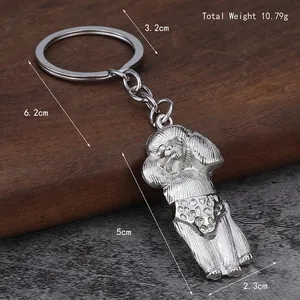 Silver metal poodle keychain featuring a sitting dog in a polka dot outfit with dimensions