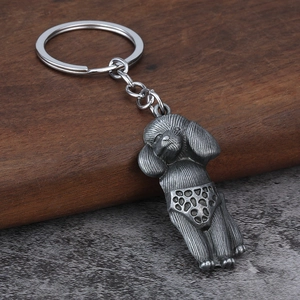 Vintage silver poodle keychain with polka dot shorts and textured fur on wood base