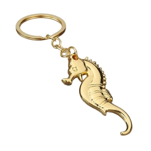 Polished golden seahorse metal keychain with detailed texture on a white background