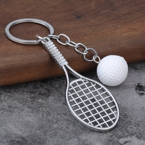 Detail of creative tennis racket and ball keychain on a rustic wooden surface