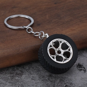 Car tire wheel rim keychain with black rubber tire and silver metal hub in 3D design