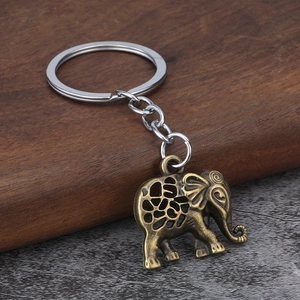 Vintage bronze elephant keychain with geometric hollow design on textured surface