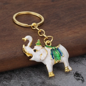 Detailed close-up of Thai elephant keychain with white enamel on a dark wood block