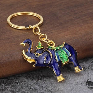 Three-dimensional elephant keychain with blue enamel and gold finish on wood base
