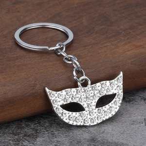 Sparkling mask-shaped keychain with crystal rhinestones on a silver metal frame