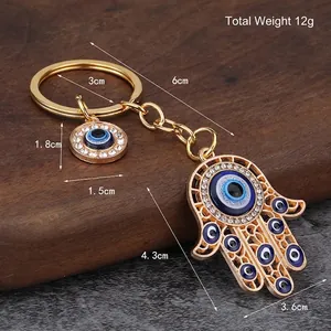 Hamsa Hand and Evil Eye car keychain in gold finish with blue enamel and rhinestones