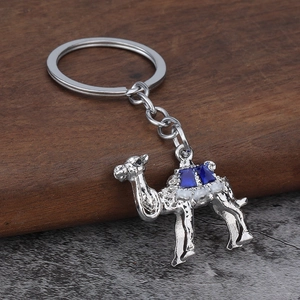 Detail of camel metal keychain featuring embossed texture and inlaid blue gemstone accents