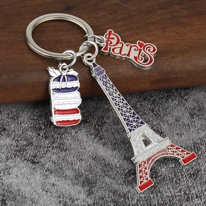 Detail of Paris keychain with Eiffel Tower, macarons, and lettering on textured background