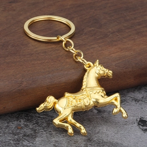 Creative golden horse keychain with detailed metal carving on a rustic stone background