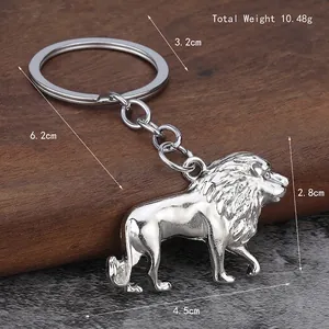 Silver 3D lion keychain with measurements on dark wood background