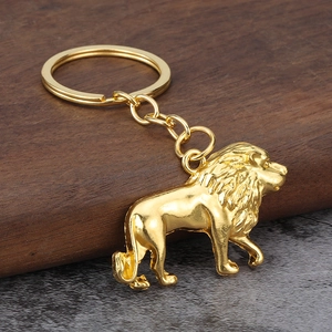 Elegant gold metal lion keychain with detailed mane on rustic wood and stone background