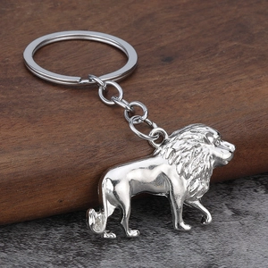 Minimalist silver metal lion keychain with detailed mane on a premium wooden stand