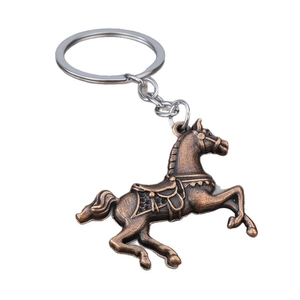 Vintage bronze metal horse keychain with intricate saddle details on a white background