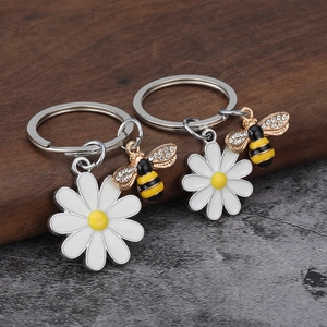 Gänseblümchen Schlüsselanhänger Set mit glitzernder Biene auf Holzgrund