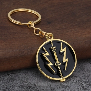 Close-up of Ukraine flag metal keychain with black enamel sword and lightning on wood