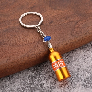 Detailed macro view of the gold NOS nitrous bottle keychain with blue valve design